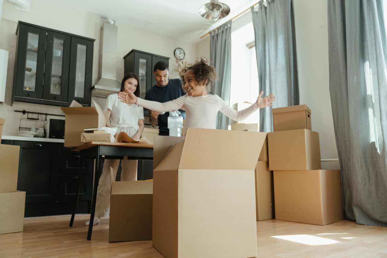 A joyful family unpacking boxes in their new home, highlighting family closeness and excitement.